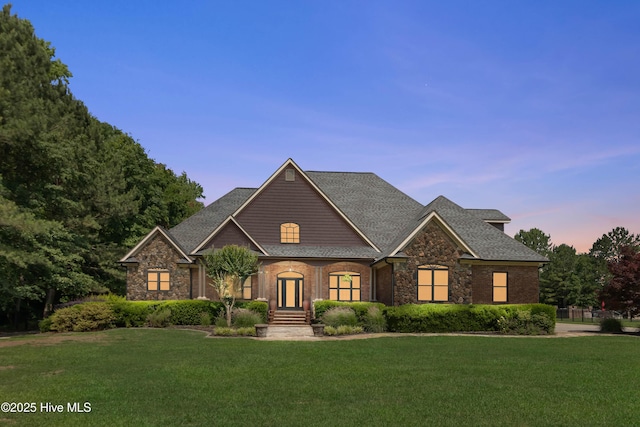 207 Hooping Crane Ln, Goldsboro, NC 27530 - view of front of home with a front lawn, stone siding, and a shingled roof