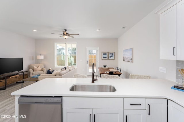 126 Jansen Ln, Winnabow, NC 28479 - kitchen with stainless steel dishwasher, a sink, light countertops, a ceiling fan, and white cabinets