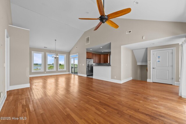 905 N Anderson Blvd, Topsail Beach, NC 28445 - unfurnished living room with high vaulted ceiling, light wood-style floors, a ceiling fan, baseboards, and a chandelier