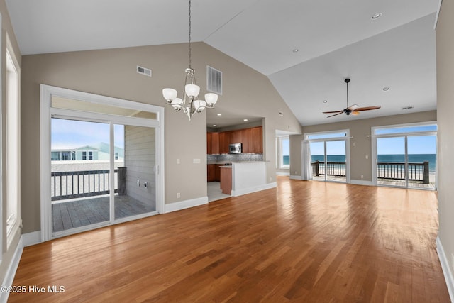 905 N Anderson Blvd, Topsail Beach, NC 28445 - unfurnished living room featuring high vaulted ceiling, light wood-style flooring, a chandelier, a ceiling fan, and a water view
