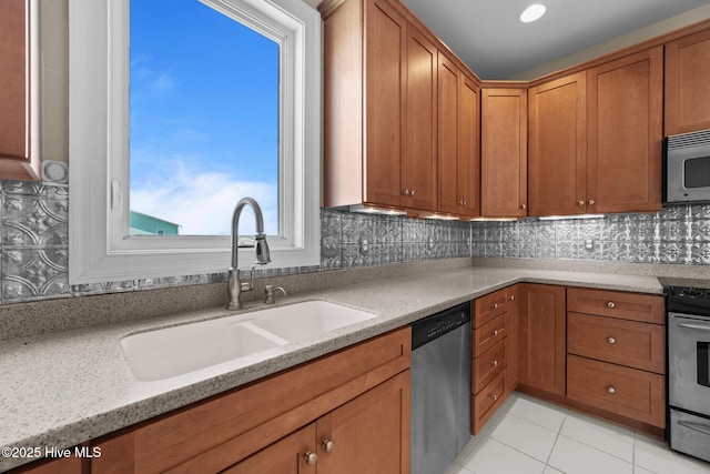 905 N Anderson Blvd, Topsail Beach, NC 28445 - kitchen with appliances with stainless steel finishes, a sink, brown cabinets, tasteful backsplash, and light tile patterned flooring