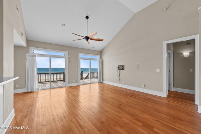 905 N Anderson Blvd, Topsail Beach, NC 28445 - unfurnished living room featuring a ceiling fan, high vaulted ceiling, light wood-style flooring, baseboards, and a water view
