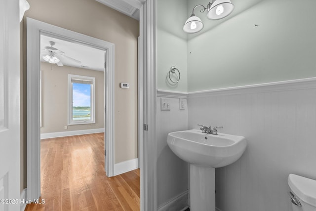 905 N Anderson Blvd, Topsail Beach, NC 28445 - bathroom featuring wood finished floors, wainscoting, toilet, a ceiling fan, and a sink