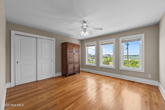 905 N Anderson Blvd, Topsail Beach, NC 28445 - unfurnished bedroom featuring baseboards, light wood-style floors, a ceiling fan, and a closet