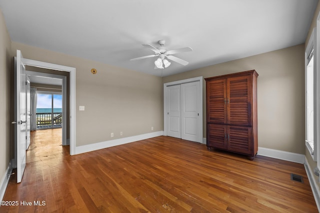 905 N Anderson Blvd, Topsail Beach, NC 28445 - unfurnished bedroom with baseboards, wood finished floors, two closets, and a ceiling fan