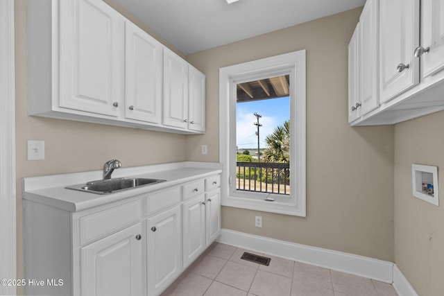 905 N Anderson Blvd, Topsail Beach, NC 28445 - washroom featuring cabinet space, washer hookup, baseboards, and light tile patterned floors