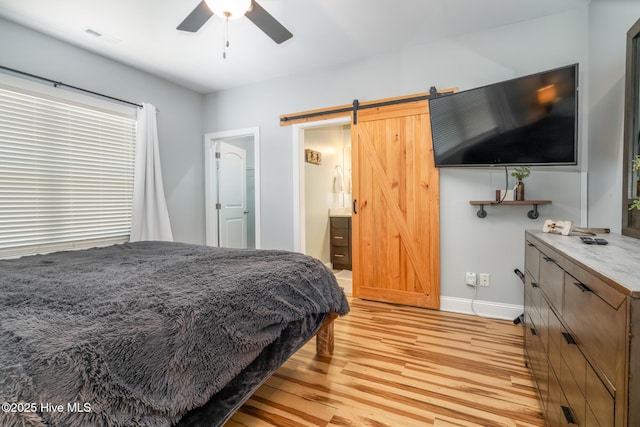 106 NW 8th St, Oak Island, NC 28465 - bedroom with a barn door, light wood-style floors, baseboards, and a ceiling fan