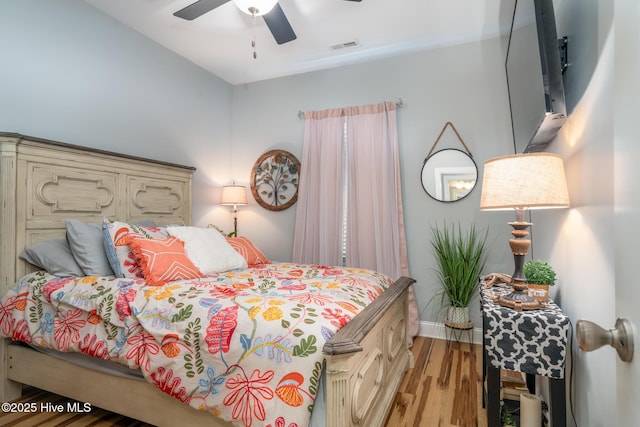 106 NW 8th St, Oak Island, NC 28465 - bedroom with wood finished floors, a ceiling fan, and baseboards