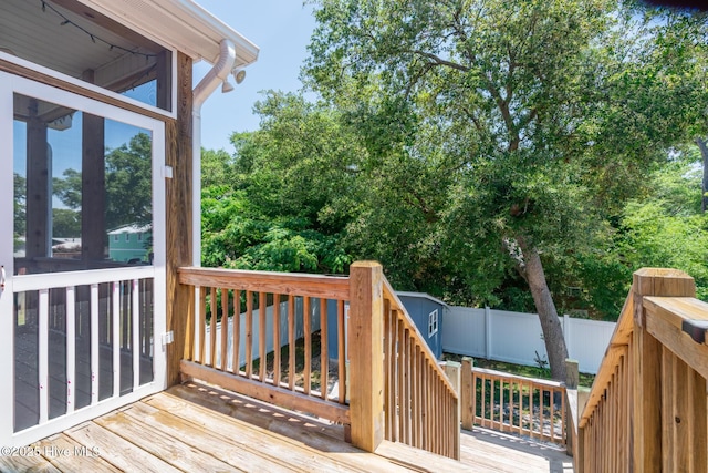 106 NW 8th St, Oak Island, NC 28465 - wooden terrace featuring a fenced backyard, a storage shed, and stairs