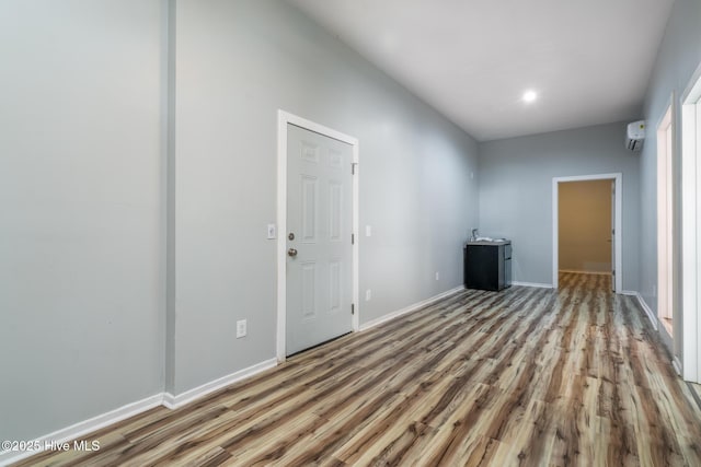 106 NW 8th St, Oak Island, NC 28465 - unfurnished room featuring wood finished floors, baseboards, a wall mounted AC, and recessed lighting