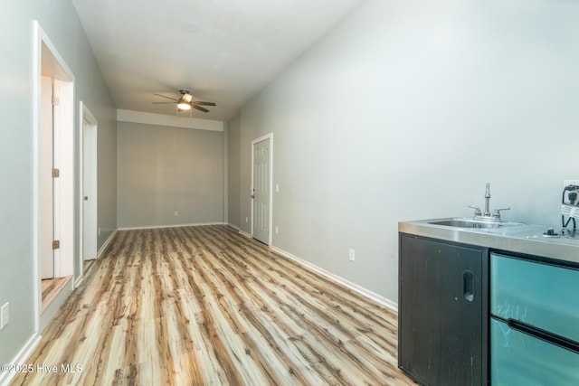 106 NW 8th St, Oak Island, NC 28465 - laundry room featuring a sink, light wood-style flooring, ceiling fan, and baseboards