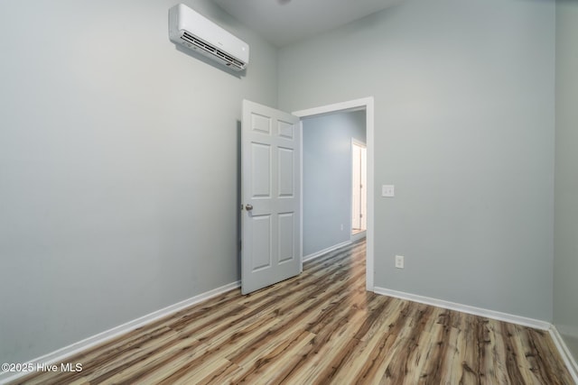 106 NW 8th St, Oak Island, NC 28465 - empty room featuring a wall unit AC, wood finished floors, and baseboards