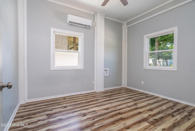 106 NW 8th St, Oak Island, NC 28465 - empty room with a wall mounted AC, plenty of natural light, ceiling fan, and wood finished floors