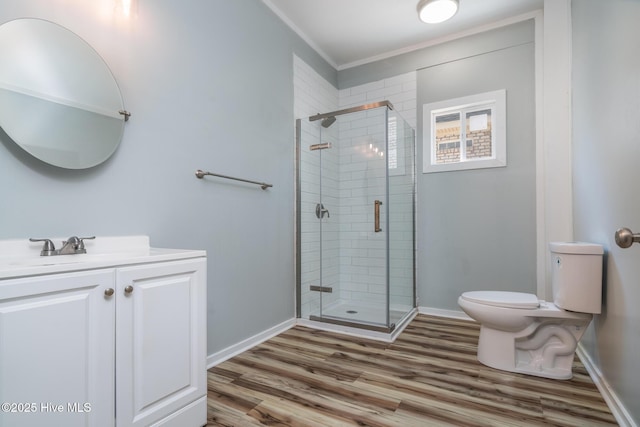 106 NW 8th St, Oak Island, NC 28465 - full bathroom with toilet, vanity, wood finished floors, a stall shower, and ornamental molding