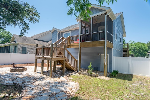 106 NW 8th St, Oak Island, NC 28465 - rear view of house with a sunroom, a deck, stairway, ceiling fan, and a fire pit