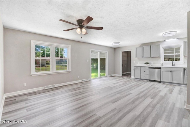1102 Elanor Ave, Goldsboro, NC 27530 - unfurnished living room featuring ceiling fan, a textured ceiling, light wood-style floors, baseboards, and a sink
