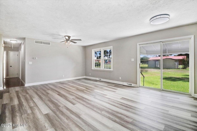 1102 Elanor Ave, Goldsboro, NC 27530 - unfurnished living room with wood finished floors, a textured ceiling, attic access, and a ceiling fan