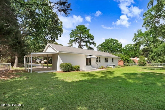 1102 Elanor Ave, Goldsboro, NC 27530 - rear view of house with an attached carport, a yard, and stucco siding