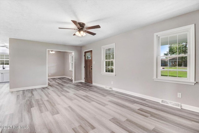 1102 Elanor Ave, Goldsboro, NC 27530 - unfurnished living room featuring ceiling fan, light wood-style floors, and baseboards
