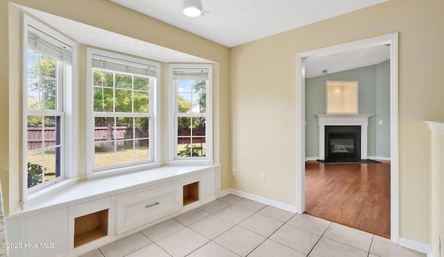 416 Point View Ct, Wilmington, NC 28411 - unfurnished dining area with light tile patterned flooring, a glass covered fireplace, baseboards, and lofted ceiling