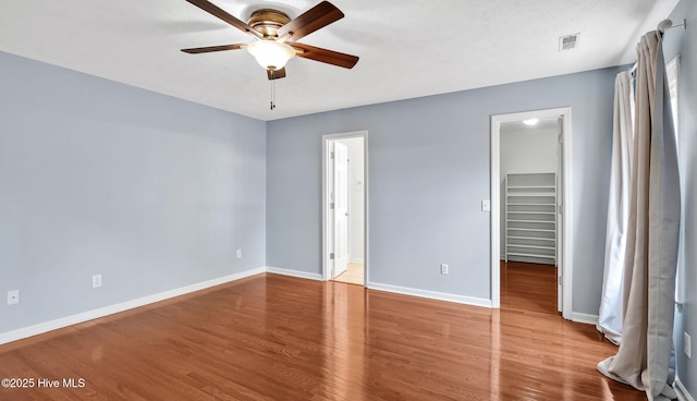 416 Point View Ct, Wilmington, NC 28411 - unfurnished bedroom featuring a spacious closet, wood finished floors, baseboards, a closet, and ceiling fan