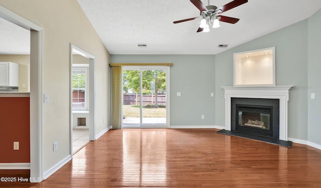 416 Point View Ct, Wilmington, NC 28411 - unfurnished living room with wood finished floors, a ceiling fan, a glass covered fireplace, baseboards, and vaulted ceiling