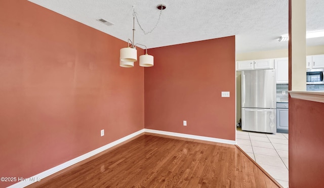 416 Point View Ct, Wilmington, NC 28411 - unfurnished dining area featuring baseboards, light wood finished floors, and a textured ceiling