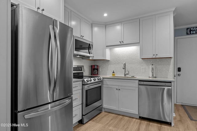 2008 E Fort Macon Rd Unit A-1, Atlantic Beach, NC 28512 - kitchen with appliances with stainless steel finishes, a sink, light wood finished floors, decorative backsplash, and white cabinets