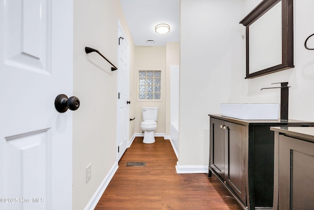 562 Anchor Way, Kure Beach, NC 28449 - bathroom with vanity, toilet, wood finished floors, baseboards, and washtub / shower combination