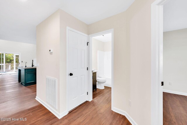 562 Anchor Way, Kure Beach, NC 28449 - hall with wood finished floors, a sink, and baseboards