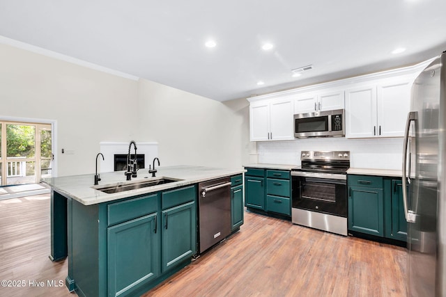 562 Anchor Way, Kure Beach, NC 28449 - kitchen with appliances with stainless steel finishes, a sink, white cabinetry, green cabinetry, and a center island with sink