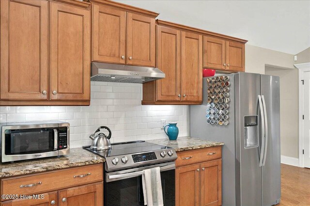 2121 Maple Leaf Dr, Southport, NC 28461 - kitchen with appliances with stainless steel finishes, under cabinet range hood, and brown cabinets