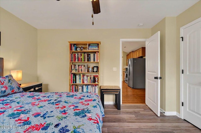 2121 Maple Leaf Dr, Southport, NC 28461 - bedroom featuring freestanding refrigerator, wood finished floors, baseboards, and ceiling fan