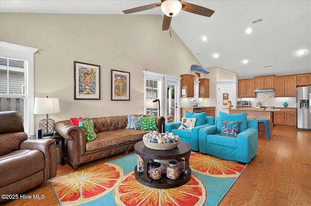 2121 Maple Leaf Dr, Southport, NC 28461 - living area with high vaulted ceiling, a ceiling fan, light wood-type flooring, and recessed lighting