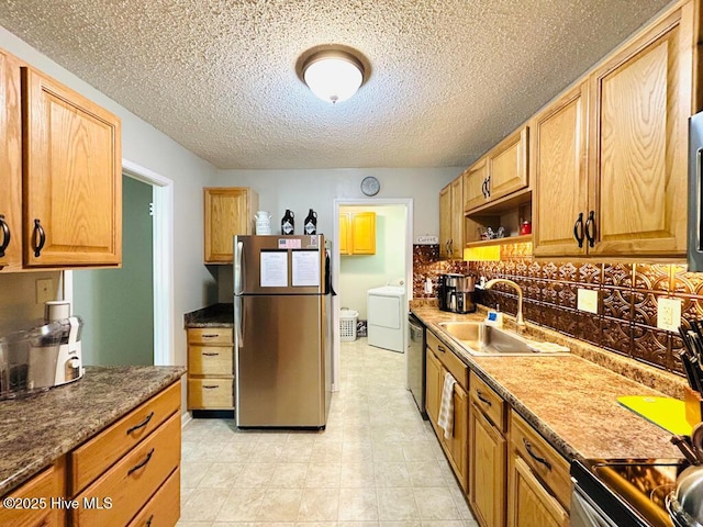 502 Dogwood Ln, Jacksonville, NC 28540 - kitchen featuring stainless steel appliances, a sink, washer / clothes dryer, a textured ceiling, and backsplash
