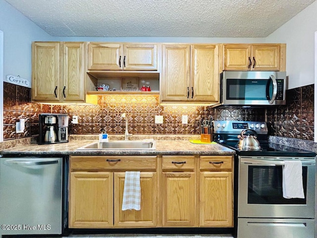 502 Dogwood Ln, Jacksonville, NC 28540 - kitchen featuring stainless steel appliances, a sink, light brown cabinetry, a textured ceiling, and decorative backsplash