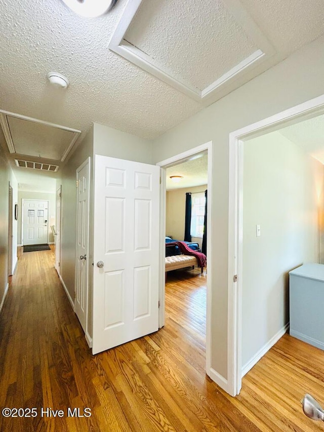 502 Dogwood Ln, Jacksonville, NC 28540 - hall with attic access, wood finished floors, a textured ceiling, and baseboards