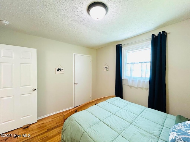 502 Dogwood Ln, Jacksonville, NC 28540 - bedroom with wood finished floors, a textured ceiling, and baseboards
