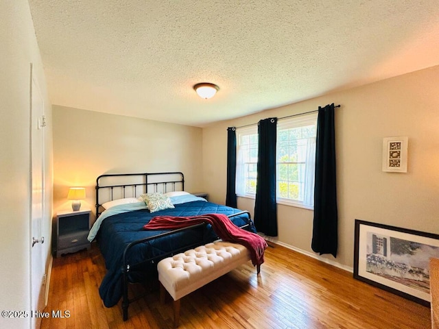 502 Dogwood Ln, Jacksonville, NC 28540 - bedroom featuring wood finished floors, a textured ceiling, and baseboards