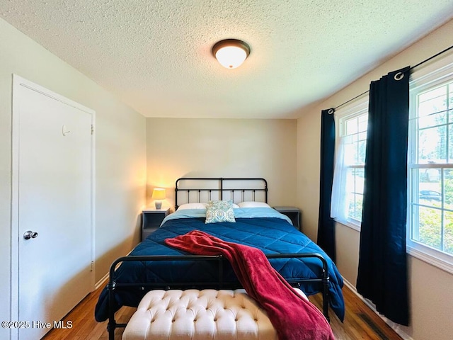502 Dogwood Ln, Jacksonville, NC 28540 - bedroom with wood finished floors, a textured ceiling, and baseboards