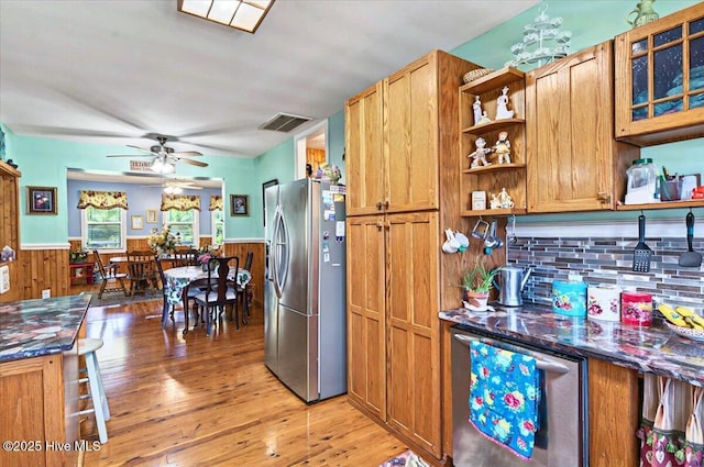245 Green Bay Rd NW, Ocean Isle Beach, NC 28469 - kitchen with stainless steel fridge with ice dispenser, open shelves, wainscoting, light wood-style flooring, and brown cabinets