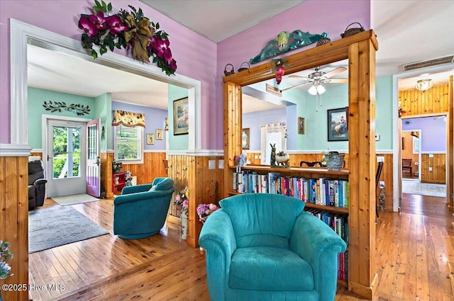 245 Green Bay Rd NW, Ocean Isle Beach, NC 28469 - sitting room featuring wainscoting, wooden walls, hardwood / wood-style flooring, and a ceiling fan