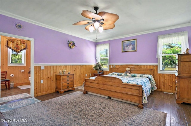 245 Green Bay Rd NW, Ocean Isle Beach, NC 28469 - bedroom with multiple windows, hardwood / wood-style flooring, wainscoting, connected bathroom, and crown molding
