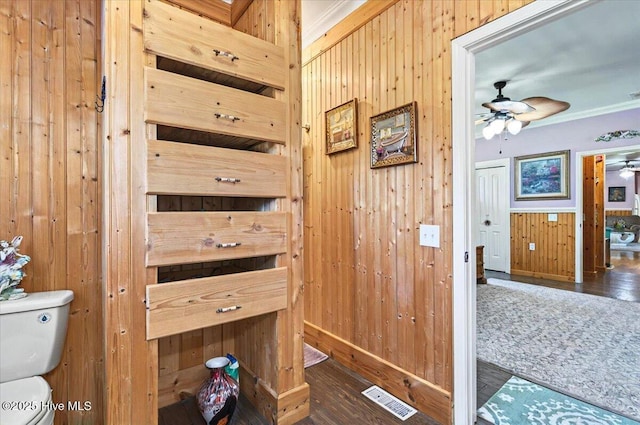 245 Green Bay Rd NW, Ocean Isle Beach, NC 28469 - detailed view of wood finished floors, wooden walls, crown molding, ceiling fan, and baseboards