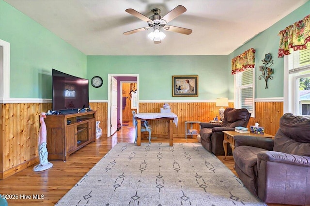 245 Green Bay Rd NW, Ocean Isle Beach, NC 28469 - living area with a wainscoted wall, wood walls, wood finished floors, and a ceiling fan