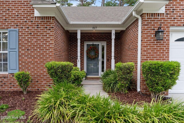 817 Glenarthur Dr, Wilmington, NC 28412 - doorway to property featuring brick siding, an attached garage, and a shingled roof