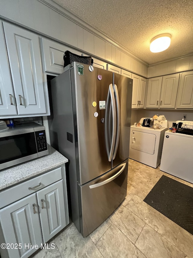 1811 Hermitage Rd NW, Wilson, NC 27896 - kitchen with washer and clothes dryer, stainless steel appliances, a textured ceiling, and light countertops
