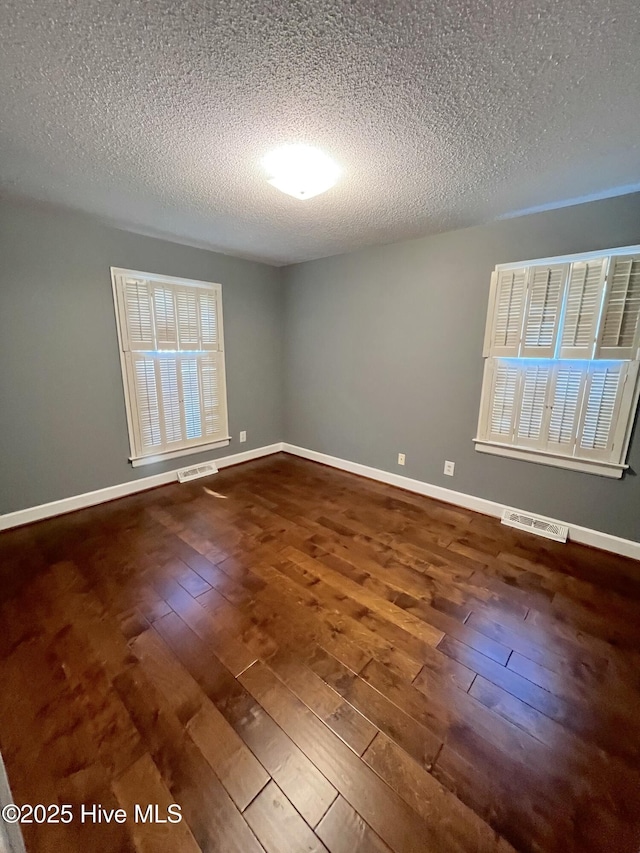 1811 Hermitage Rd NW, Wilson, NC 27896 - empty room with dark wood-style floors, a textured ceiling, and baseboards