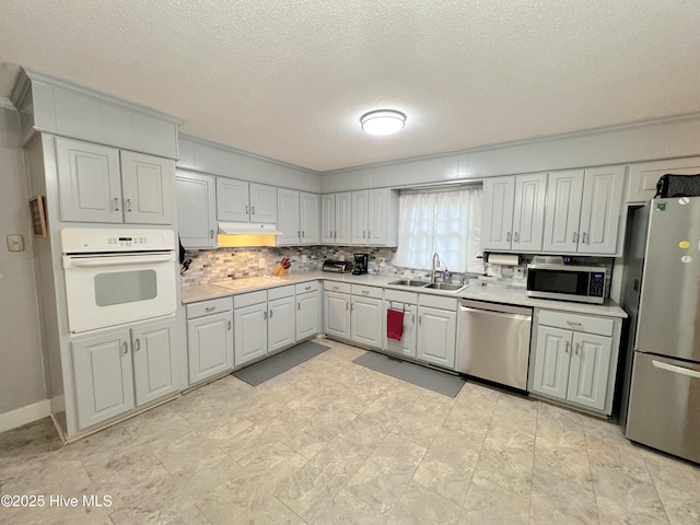 1811 Hermitage Rd NW, Wilson, NC 27896 - kitchen with appliances with stainless steel finishes, a sink, a textured ceiling, light countertops, and decorative backsplash