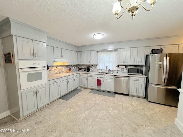 1811 Hermitage Rd NW, Wilson, NC 27896 - kitchen with appliances with stainless steel finishes, a chandelier, light countertops, a sink, and tasteful backsplash